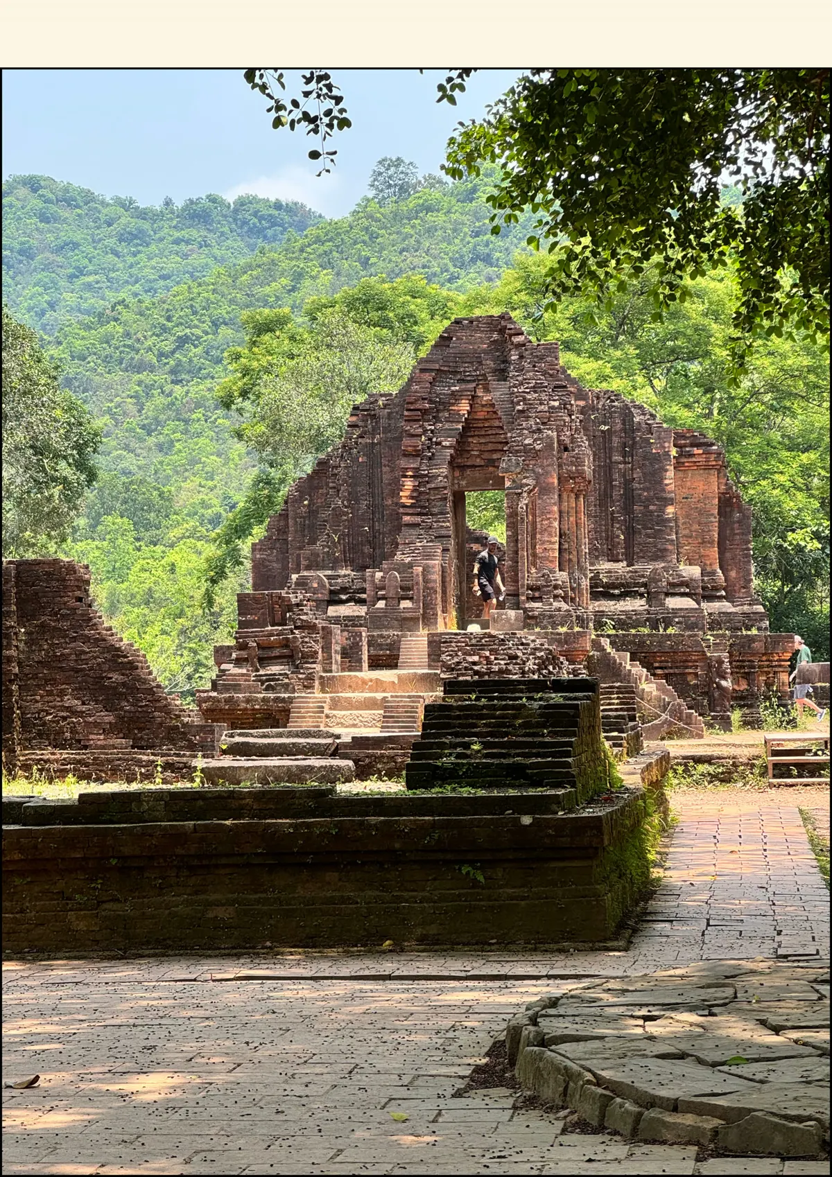 Ancient red-brick Cham temple ruins among trees and green hills